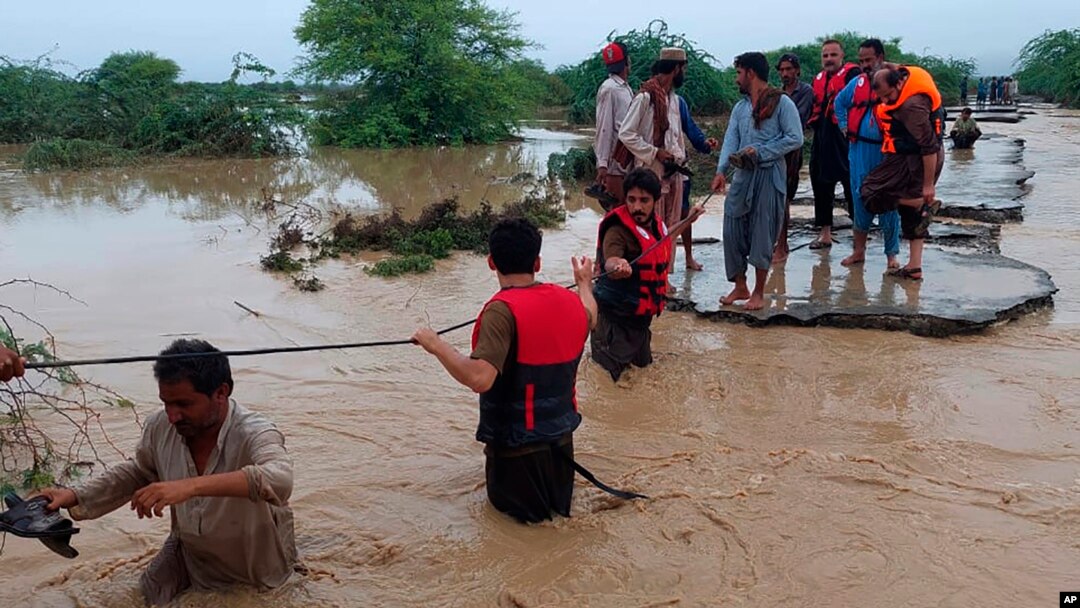 FILE - Tim SAR membantu penduduk desa mengungsi dari banjir setelah hujan lebat, di Lasbella, distrik di provinsi Baluchistan barat daya Pakistan, 26 Juli 2022. (AP/Hamdan Khan, File) Tim pencari Pakistan menemukan puing-puing helikopter yang jatuh Senin, 1 Agustus 2022.