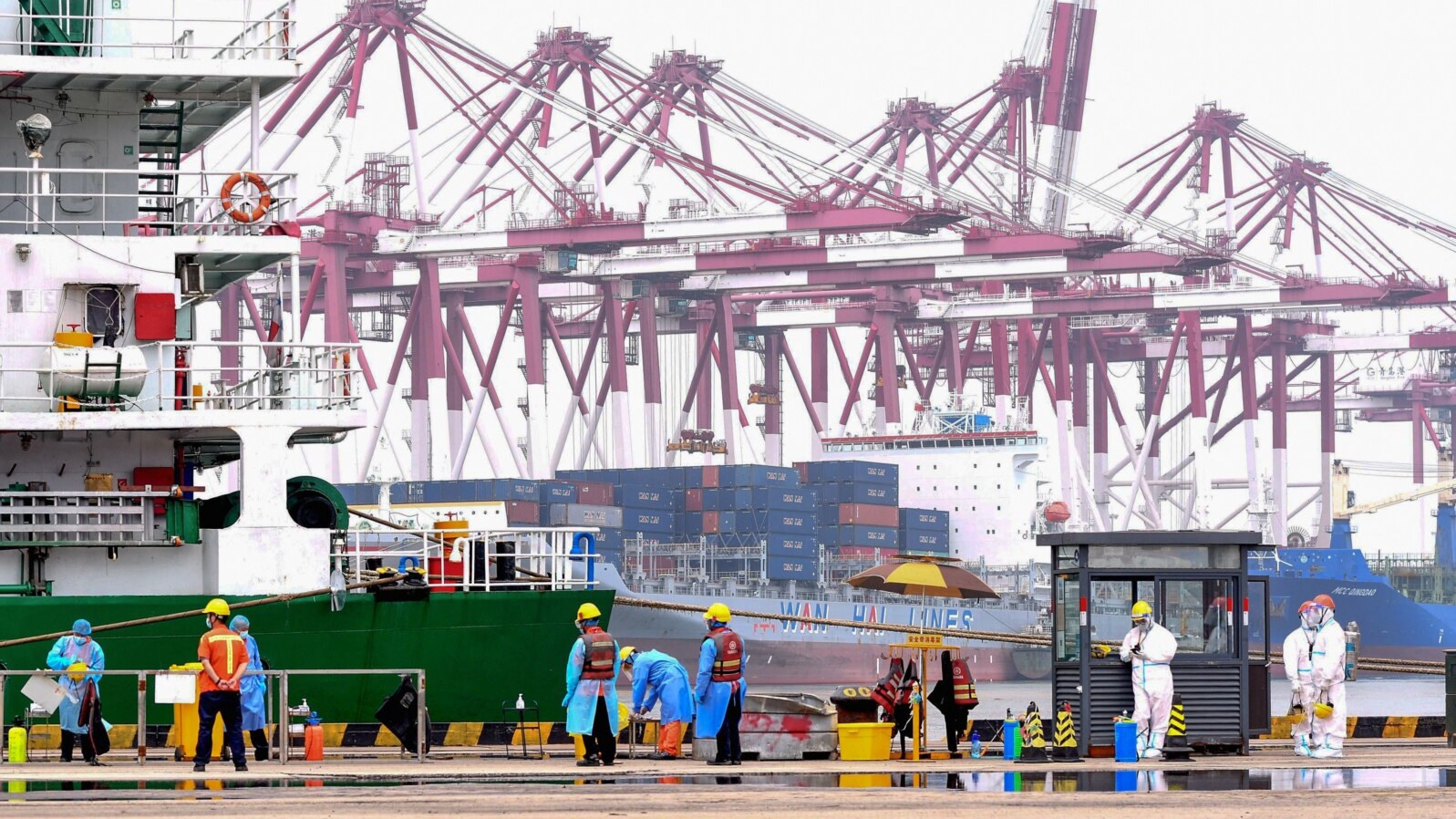 FILE - Workers disinfect an area at a port in Qingdao, in China's eastern Shandong province on July 13, 2022. 