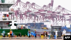 FILE - Workers disinfect an area at a port in Qingdao, in China's eastern Shandong province on July 13, 2022. 