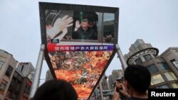 北京一家购物中心外面的一个大型屏幕上播放着中国国家主席习近平访问新疆的新闻画面。（2022年7月15日）