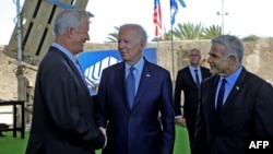 U.S. President Joe Biden (C), Israeli caretaker Prime Minister Yair Lapid (R) and Defense Minister Benny Gantz, stand in front of Israel's Iron Dome defense system during a tour at Ben Gurion Airport near Tel Aviv, July 13, 2022. 