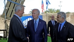 Američki predsjednik Joe Biden, izraelski premijer Yair Lapid  i ministar odbrane Benny Gantz, stoje ispred izraelskog odbrambenog sistema Iron Dome tokom obilaska aerodroma Ben Gurion u blizini Tel Aviva, 13. jula 2022. 