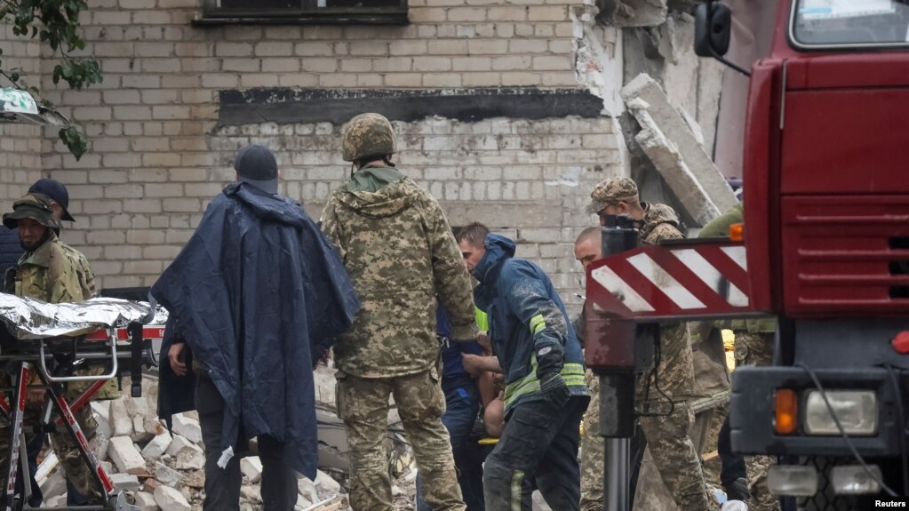 搜救人员在顿涅茨克州查西夫亚尔镇一座被俄军导弹击中的公寓楼废墟中救出一名幸存者。(2022年7月11日)(photo:VOA)