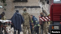 搜救人员在顿涅茨克州查西夫亚尔镇一座被俄军导弹击中的公寓楼废墟中救出一名幸存者。(2022年7月11日)