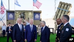 President Joe Biden talks with Israeli Defense Minister Benny Gantz, left, and Israeli Prime Minister Yair Lapid, right, as he is shown views of aerial defense systems, July 13, 2022, in Tel Aviv.