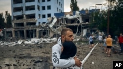 A couple reacts after the Russian shelling in Mykolaiv, Ukraine, on Aug. 3, 2022. Supermarket, high-rise buildings and pharmacy were damaged, according to local media.