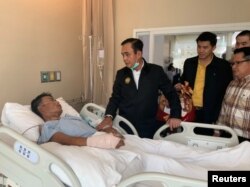 Thailand's Prime Minister Prayuth Chan-ocha visits an injured man in a hospital following a shooting rampage involving a Thai soldier, in Nakhon Ratchasima, Thailand, Feb. 9, 2020.