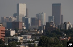 A smoky haze envelopes the skyscrapers and Rocky Mountains that usually can be seen as a backdrop to the city from a high-rise building, Aug. 20, 2018, in Denver.
