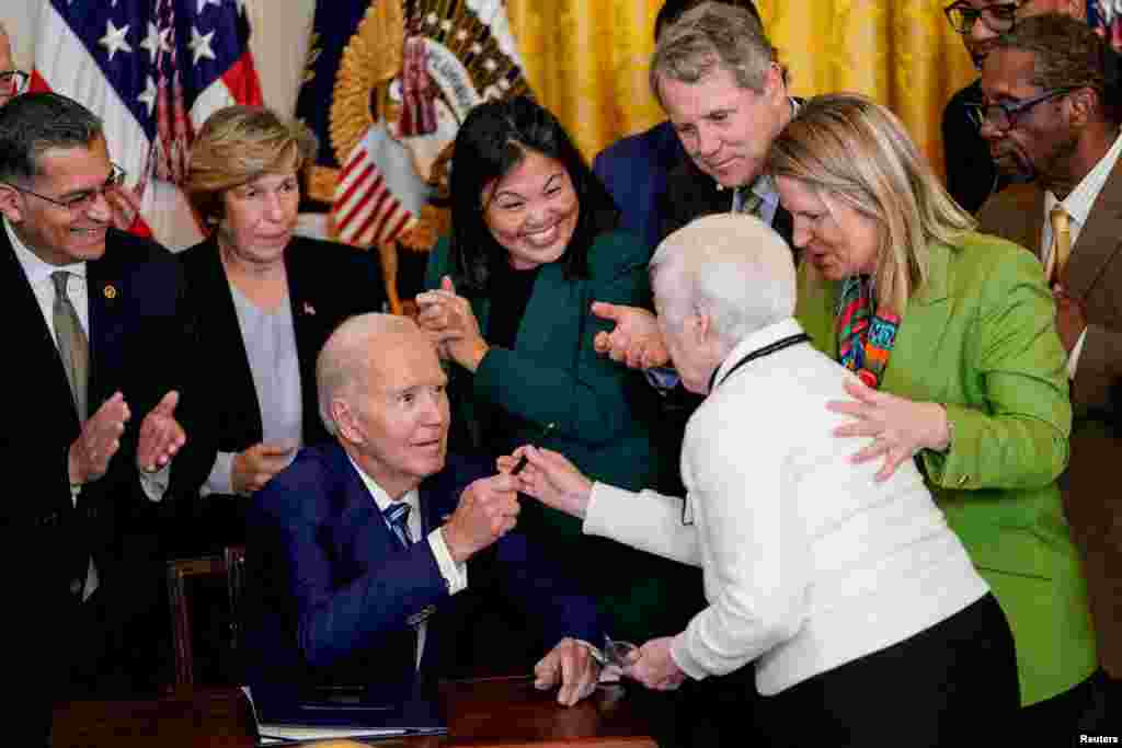 U.S. President Joe Biden hands a pen to Bette Marafino, President of the Connecticut Chapter of the Alliance for Retired Americans, in a bill signing ceremony for the "Social Security Fairness Act" at the White House, in Washington, Jan. 5, 2025.