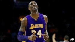 FILE - In this Dec. 1, 2015, photo, Los Angeles Lakers' Kobe Bryant smiles as he jogs to the bench during the first half of an NBA basketball game against the Philadelphia 76ers, in Philadelphia, Pennsylvania.