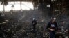 FILE - Journalists walk inside a destroyed warehouse for storing food, after an attack from Russia in Brovary, on the outskirts of Kyiv, Ukraine, March 29, 2022. 