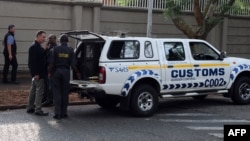 ARCHIVES - Les forces de l'ordre sud-africaines arrivent pour fouiller le complexe de la famille Gupta, le 16 avril 2018 à Johannesburg.