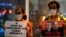 National Indigenous Foundation (FUNAI) employees hold posters with images of British journalist Dom Phillips, left, and Indigenous official Bruno Araujo Pereira during a vigil in Brasilia, Brazil, June 9, 2022. The sign at left reads "FUNAI Employees' Lives Matter" in Portuguese.