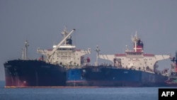 Kapal tanker minyak berbendera Liberia Ice Energy (kiri) memindahkan minyak mentah dari kapal tanker minyak berbendera Rusia Lana (kanan) di lepas pantai Karystos, di Pulau Evia, pada 29 Mei 2022, sebagai ilustrasi. (Foto: : AFP)