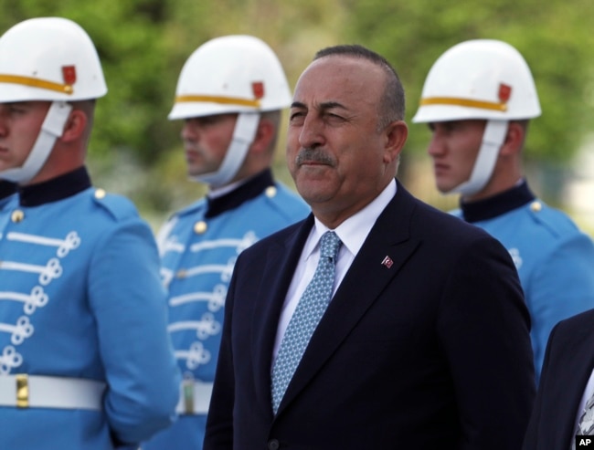 Turkish Foreign Minister Mevlut Cavusoglu stands with a military honour guard, in Ankara, Turkey, Wednesday, June 1, 2022. Cavusoglu sent a letter to the U.N. formally requesting that his country be referred to as "Türkiye," the state-run news agency reported. (AP Photo/Burhan Ozbilici)