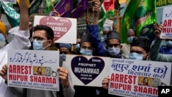 FILE - Indian Muslims hold placards demanding the arrest of Nupur Sharma, a spokesperson of the governing BJP as they react to derogatory references to Islam and the Prophet Muhammad made by her, during a protest in Mumbai, India, June 6, 2022.