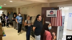 California voters wait in line to cast their ballots in the primary election minutes before the ballots close in the Echo Park Recreation Center in Los Angeles, June 7, 2022.