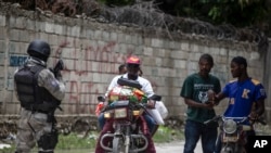 Yon polisye fe patwouy nan lari pandan yon operasyon anti-gang nan Croix-des-Missions, o no Potoprens, Ayiti, 28 Avril 2022. 