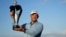 Charl Schwartzel of South Africa holds up the trophy for winning the inaugural LIV Golf Invitational at the Centurion Club in St. Albans, England, June 11, 2022.