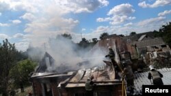 Firefighters work following a military strike, amid Russia's attack on Ukraine, on the outskirt of Kharkiv, Ukraine, June 8, 2022. 