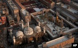 FILE- An Aerial view shows Gyanvapi mosque, left, and Kashiviswanath temple on the banks of the river Ganges in Varanasi, India, Dec. 12, 2021.