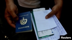Frank Eduardo sostiene un pasaporte y billetes en La Habana, Cuba, el 9 de marzo de 2022.