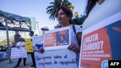 Lorena Aguilar memegang poster dalam aksi protes terhadap Presiden El Savador Nayib Bukele di luar gedung pertemuan di Los Angeles, yang menjadi tempat berlangsungnya KTT Amerika, pada 6 Juni 2022. (Foto: AFP/Apu Gomes)