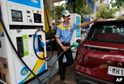 FILE - An employee of a Bharat petroleum fuel station fills petrol in a vehicle in Mumbai, India, June 11, 2022. India and other Asian nations are becoming an increasingly vital source of oil revenues for Moscow.