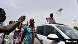 Diebedo Francis Kéré, un architecte qui a remporté le prix Pritzker, célèbre sort de l'aéroport dans une voiture traversant dans les rues de Tenkodogo, au Burkina Faso le 4 juin 2022. (Photo Reuters/Anne Mimault)