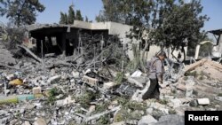 FILE - An airport staffer walks through the rubble of a building destroyed by Saudi-led air strikes at Sanaa Airport in Sanaa, Yemen, Dec. 21, 2021.