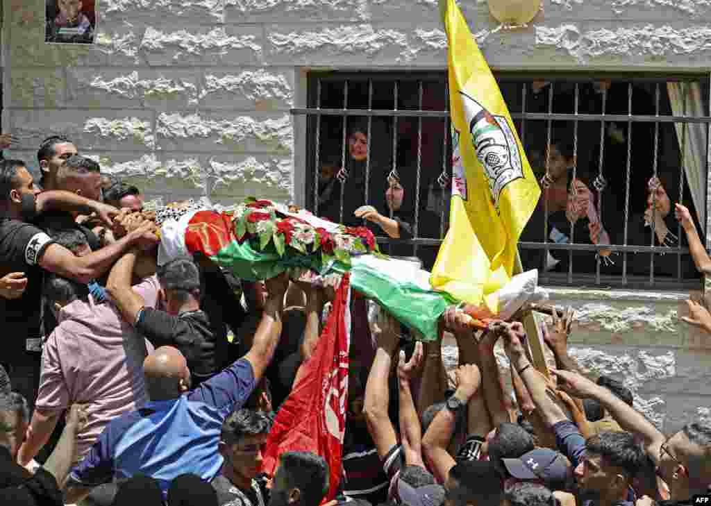 Palestinian mourners carry the body of 17-year-old Odeh Odeh, who was hit in the chest the day before by what the Palestinian health ministry said was an Israeli bullet, during his funeral in the village of Al-Madiya.