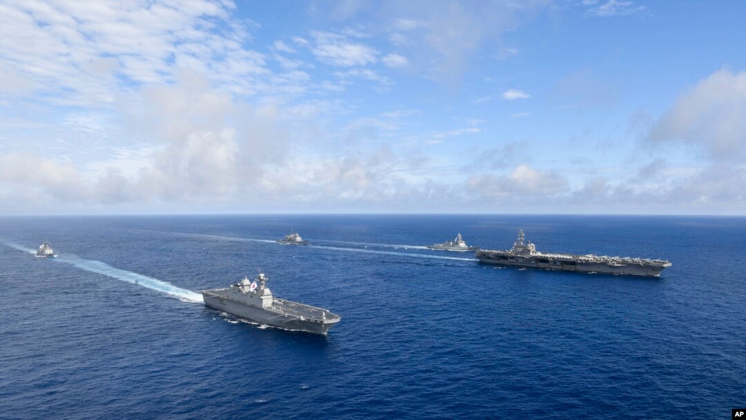 Kapal induk bertenaga nuklir AS USS Ronald Reagan, kanan, dan kapal helikopter platform pendaratan (LPH) Korea Selatan (LPH) Marado, kedua dari kiri, berlayar selama latihan militer bersama di lokasi yang dirahasiakan, Sabtu, 4 Juni 2022. (Foto: via AP)