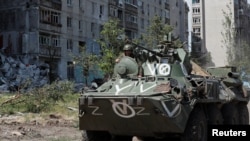 Un miembro del servicio de las tropas prorrusas viaja sobre un vehículo blindado de transporte de personal en medio de la invasión rusa de Ucrania, en la ciudad de Popasna en la región ucraniana de Lugansk, el 2 de junio de 2022.
