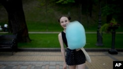 A girl holds cotton candy at a square in Kyiv, Ukraine, June 10, 2022.