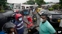 People wait in a long queues to buy fuel for their vehicles at a filling station in Colombo, Sri Lanka, June 11, 2022. 