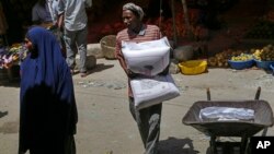 FILE - A man carries a sack of wheat flour imported from Turkey in the Hamar-Weyne market in Mogadishu, Somalia, May 26, 2022. Families across Africa are paying about 45% more for wheat flour as Russia's war in Ukraine blocks exports from the Black Sea.