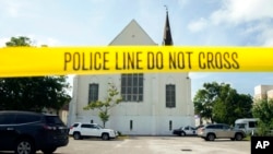 FILE - Police tape surrounds the parking lot behind the AME Emanuel Church in Charleston, SC, on June 19, 2015, after a shooting that killed nine people.