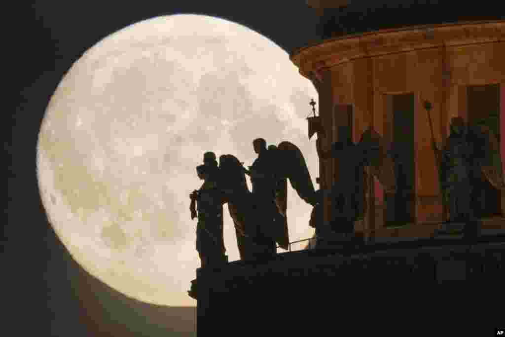 Sculptures of angels at the St. Isaak&#39;s Cathedral are silhouetted on the full moon in St. Petersburg, Russia, June 13, 2022.