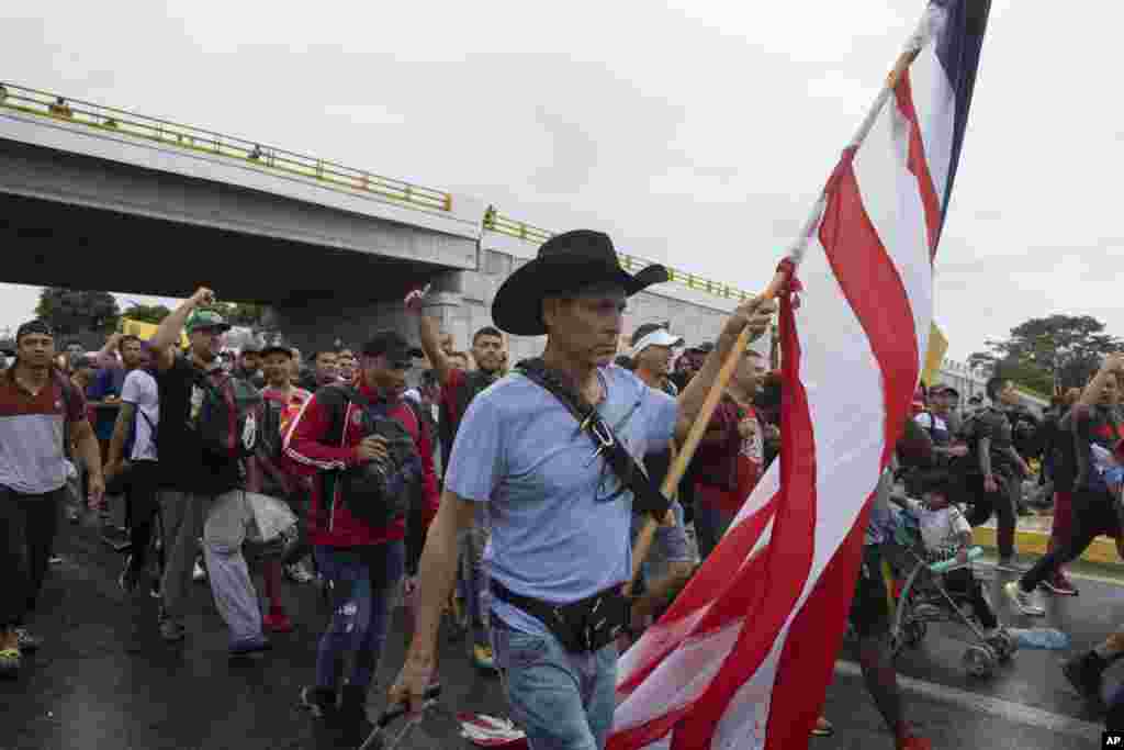A migrant carries a U.S. flag during a migrant caravan leaving the city of Tapachula in Chiapas state, Mexico.