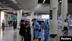 A police officer in a protective suit checks on a commuter at a subway station, after the lockdown placed to curb the coronavirus disease (COVID-19) outbreak was lifted in Shanghai, June 2, 2022.