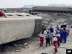 Tim penyelamat tiba di lokasi kecelakaan kereta penumpang yang tergelincir sebagian di dekat kota gurun Tabas di Iran timur, Rabu, 8 Juni 2022. (Iranian Red Crescent Society via AP)