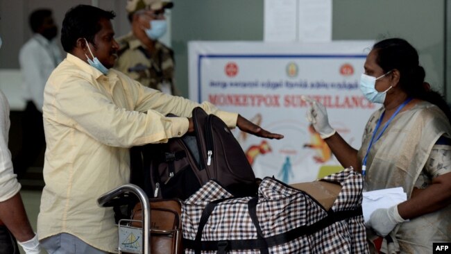 FILE - Health workers screen passengers arriving from abroad for monkeypox symptoms at Anna International Airport in Chennai, India, June 3, 2022.