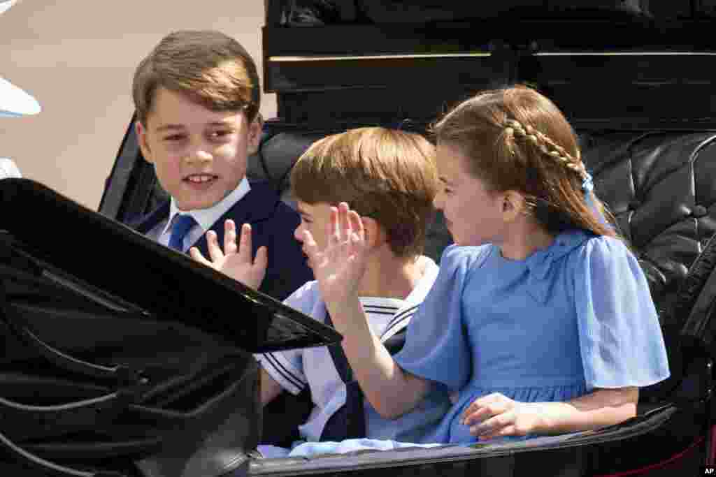 Prince George, left, Prince Louis and Princess Charlotte ride in a carriage as they make their way to the Trooping the Color, in London, June 2, 2022.