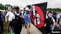 Oficiales de policía y manifestantes llevan un cartel mientras la gente participa en la 'Marcha por nuestras vidas', una de una serie de protestas nacionales contra la violencia armada, en Washington, DC, el 11 de junio de 2022.