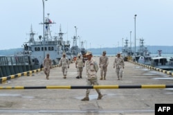 FILE - Cambodian navy personnel walk on a jetty in Ream naval base in Preah Sihanouk province during a government organized media tour, July 26, 2019.