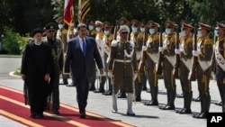 Venezuela's President Nicolas Maduro, third left, reviews an honor guard as he is accompanied by his Iranian counterpart Ebrahim Raisi, left, during his official welcoming ceremony at the Saadabad Palace in Tehran, Iran, Saturday, June 11, 2022. 