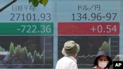 Papan saham elektronik menunjukkan indeks Nikkei 225 Jepang dan nilai tukar dolar AS terhadap yen Jepang di sebuah perusahaan sekuritas, di Tokyo, Jepang, Senin, 13 Juni 2022. (AP Photo/Eugene Hoshiko)