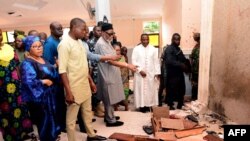 Ondo State governor Rotimi Akeredolu (3rd L) points to blood the stained floor after an attack by gunmen at St. Francis Catholic Church in Owo town, southwest Nigeria on June 5, 2022. 