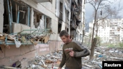 FILE PHOTO: Local resident Viacheslav walks on debris of a residential building damaged by a military strike, as Russia's attack on Ukraine continues, in Sievierodonetsk, Luhansk region, Ukraine April 16, 2022.