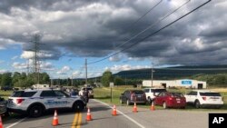 Patrullas bloquean una calle frente a una instalación donde se produjo un tiroteo cerca de Smithsburg, Maryland, el jueves 9 de junio de 2022. (AP Foto/Michael Kunzelman)